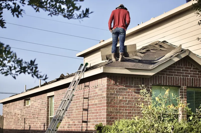 Professional roofer working on a residential roof in Broaddus